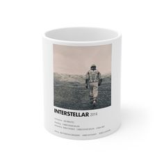 a white coffee mug with an image of a man walking in the desert