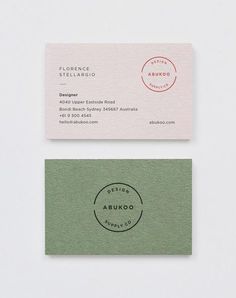 two business cards sitting side by side on top of each other, one in green and the other in pink