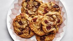 chocolate chip cookies with pecans and cranberries on a pink plate, ready to be eaten