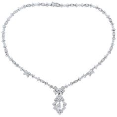 A feminine necklace made in Edwardian style featuring a 0.54 carat round cut diamond drop. The ribbons and bows of this platinum necklace are studded with 3.82 carats of round cut diamonds with a milgrain border. The detachable drop has a hook so that is may be worn as a pendant. The seamless finish provides a box clasp closure and safety latch. Necklace Length: 16.25 inches Necklace Width: 0.25 inches Drop Length: 1.50 inches Drop Width: 0.75 inches Formal Baguette Diamond Necklaces, Elegant Platinum Diamond Necklace With Baguette Diamonds, Elegant Platinum Necklace With Baguette Diamonds, Elegant Formal Diamond Necklace With Baguette Diamonds, Elegant Necklace With Baguette Diamonds For Formal Occasion, Elegant Formal Necklace With Baguette Diamonds, Elegant Baguette Diamond Necklaces For Formal Occasions, Elegant Formal Necklaces With Baguette Diamonds, Formal Pendant Diamond Necklace With Baguette Diamonds