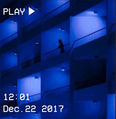 an image of a person walking up the stairs in a building with blue lights on it