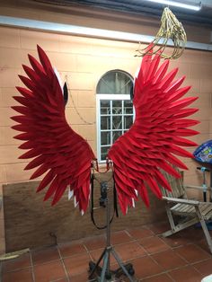 an artistic sculpture made out of red paper wings