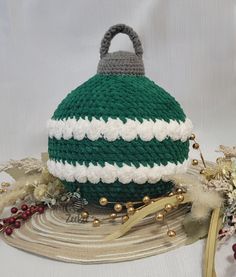 a crocheted green and white purse sitting on top of a metal platter