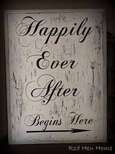 a sign that says happily ever after begins here on the side of a wall in a dark room