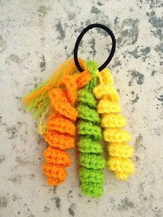 a crocheted keychain hanging from a hook on a concrete surface,