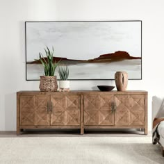 a living room with a large painting on the wall and a wooden cabinet in front of it