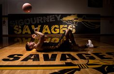 a man laying on the floor in front of a basketball