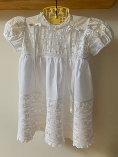 This dress came out of an estate in Massachusetts. The owner wore it in 1953, for a photo portrait taken for her first birthday. Buttonback, gathered dress is 'handkerchief' linen and is so light and sheer that it has a linen underdress, shown in 2nd photo. 6" wide applied cotton lace hem at front of dress, which reduces to 2 1/2" wide at back hem. Lace bodice and inserts at back and on sleeves. Ruffle lace at neckline and ribbon detail at front shoulders. Underdress is a simple shift style with Portrait Dress, Gathered Dress, Lace Hem, Lace Bodice, Kids Portraits, Cotton Lace, Massachusetts