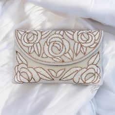 Ivory Clutch, White Clutch, Beaded Floral Clutch, Evening Bag, Brides Purse, Ideal for Weddings and Parties, Clutch Purse, Gift Idea, Christmas Gift,  This stunning handmade bridal clutch is a true masterpiece of elegance and craftsmanship. Made with raw silk and featuring intricate beading and crystal floral work, this clutch is designed to be the perfect accessory for your special day. The beautiful beaded design adds a touch of glamour, while the crystal floral motifs provide a delicate, roma Handmade Chic Clutch, Elegant Handmade Beige Clutch, Hand Embellished Beige Bag For Wedding, Beige Hand Embellished Wedding Bag, Beige Hand Embellished Bag For Wedding, Elegant Embroidered Beige Clutch, Elegant Beige Wedding Clutch, Luxury Beaded Clutch For Wedding, Luxury Cream Clutch For Wedding