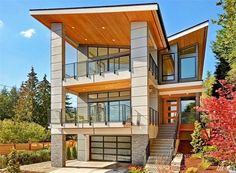 a two story house with lots of windows and balconies on the second floor