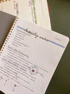 a spiral notebook sitting on top of a desk next to a pen and calculator