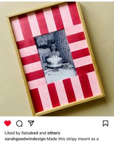 a red and white striped photo frame with a small cake in it's center