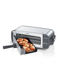 a toaster oven with pizzas in it on the side and an appliance coming out