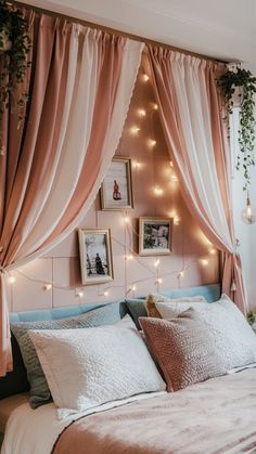 a bed with pink curtains and lights hanging from the headboard, along with pictures on the wall