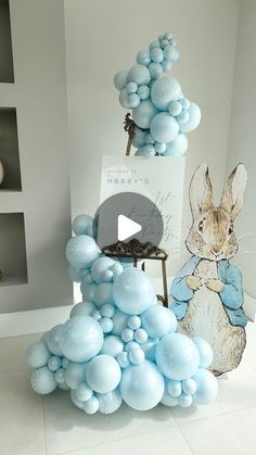 blue balloons are stacked on top of each other in the shape of a tower with an image of a rabbit