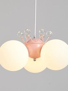 a pink ceiling light with three white balls hanging from it's center and two round lights on each side