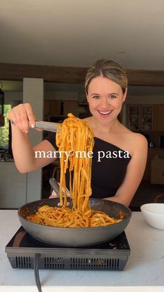 a woman is eating spaghetti from a skillet