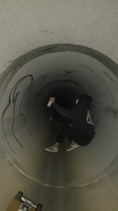 a skateboarder is going through a pipe with graffiti on it