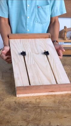 a person holding two wooden crosses in front of a piece of wood that has been cut into pieces