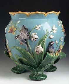 a blue vase with flowers and birds painted on it