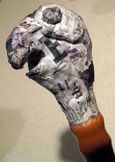 an animal made out of newspaper sitting on top of a table