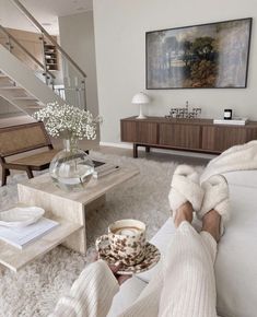 a person sitting on the floor with their feet up in front of a coffee table