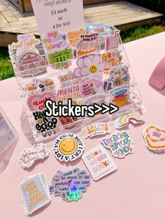 some stickers sitting on top of a table next to a sign that says stickers