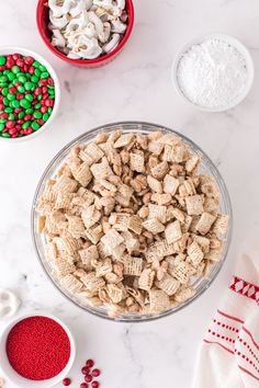 a bowl filled with cereal next to bowls of candy canes and marshmallows