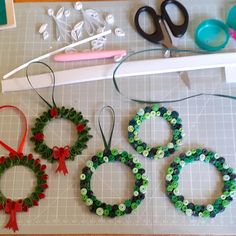 three christmas wreaths made out of bead and ribbon are sitting on a cutting board