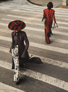 two people in costumes walking across a street