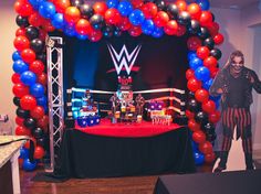 an entrance to a wrestling event decorated with red, white and blue balloons in the shape of a ring