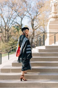 a woman in graduation gown standing on steps