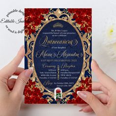 two hands holding up a red and blue wedding card with gold foilwork on it