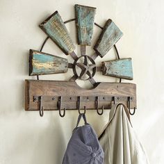 a coat rack with two coats hanging on it and a hat hanging from the hooks