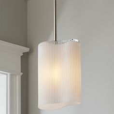 a light fixture hanging from the ceiling in a room with white walls and trimmings