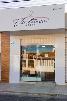 a store front with the reflection of two people walking in it's glass door