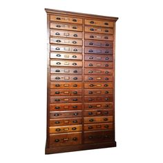 an old wooden filing cabinet with many drawers