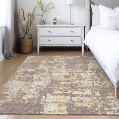 a white bed sitting next to a dresser in a bedroom