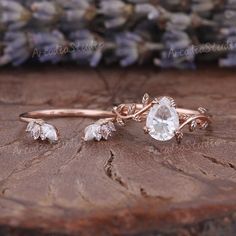 a close up of a ring on top of a piece of wood with flowers in the background