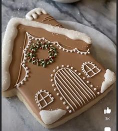 a gingerbread house decorated with icing and sprinkles on a plate