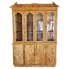 an old bamboo china cabinet with glass doors and carvings on the front, sitting against a white background