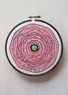 a red and white circular object with the words poppy embroidered on it's side