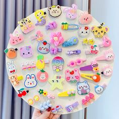 a person holding up a white tray with lots of different types of pins on it