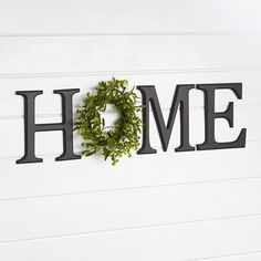 the word home is made out of metal letters with a wreath hanging from it's center