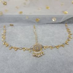 Absolutely stunning Gold and Silver Borla Mathapatti. The classic combination of gold and Silver. The matha Patti is studded with clear stones, strung together with soft studded chain. Matching drops have been added to finish the look. Beautiful piece. It Gives you a pure royal look, Ideal for Mehandi, weddings, and parties.  Please read our shop policies before making a purchase.  Drop Lenth 13cm Tikka Width: 3cm We try to take photos as natural as we can but color can be slight variations due to lighting  Jewelry Care -- Keep all the jewelry away from water, perfumes, and other harsh chemicals To clean wipe with a lint-free cloth to retain the shine Gold Temple Jewelry Tikka With Stone Work, Gold Bridal Sets With Stone Work For Celebration, Gold Bollywood Style Round Tikka, Gold Round Bollywood Tikka, Gold Tikka With Stone Work For Celebrations, Bollywood Style Gold Bridal Sets Hand Set, Gold Tikka With Stone Work For Diwali, Gold Adjustable Bridal Sets, Gold Bridal Necklace With Sparkling Diamond Stones