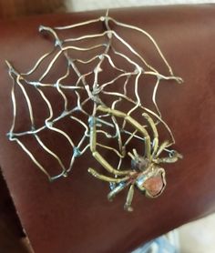 a close up of a person's arm with a spider web bracelet on it