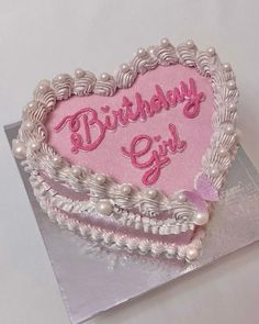 a heart shaped birthday cake with pink frosting and pearls on the edges that says,'birthday girl '