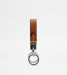 a keychain with a metal ring and brown leather strap hanging from it's side