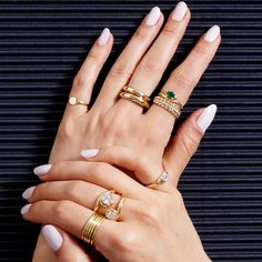 two women's hands with different rings on their fingers, one holding the other