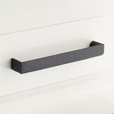 a black handle on a white cabinet door